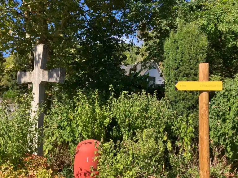 Croix de pierre et poteau indicateur jaune